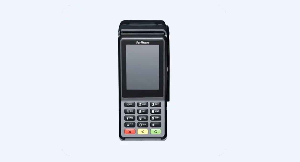 Wired Verifone credit card terminal with keypad, small screen, and attached card reader, used for non-smart transactions at Mews Terminal A