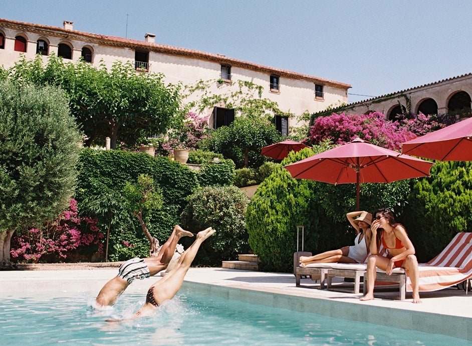 A family on holiday diving into a swimming pool.
